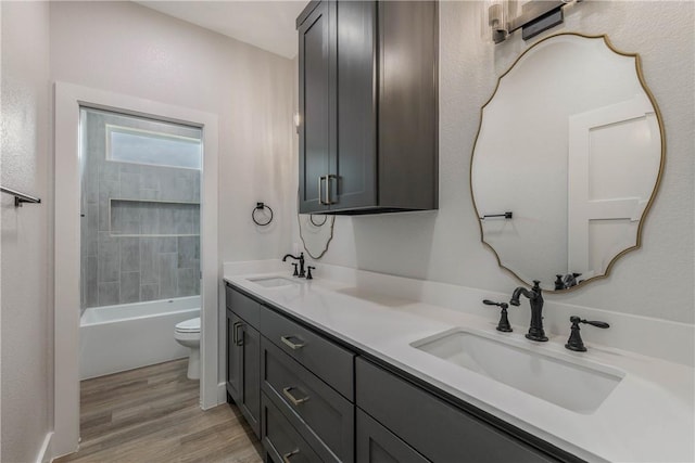 full bathroom with shower / bath combination, wood-type flooring, vanity, and toilet
