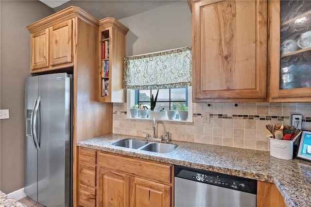 kitchen featuring stainless steel appliances, decorative backsplash, a sink, and glass insert cabinets