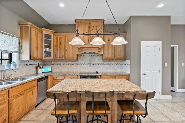 kitchen featuring a breakfast bar area, stainless steel dishwasher, light tile patterned floors, a sink, and premium range hood