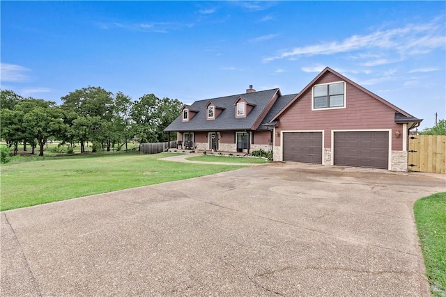 view of front of property featuring aphalt driveway, fence, stone siding, a garage, and a front lawn