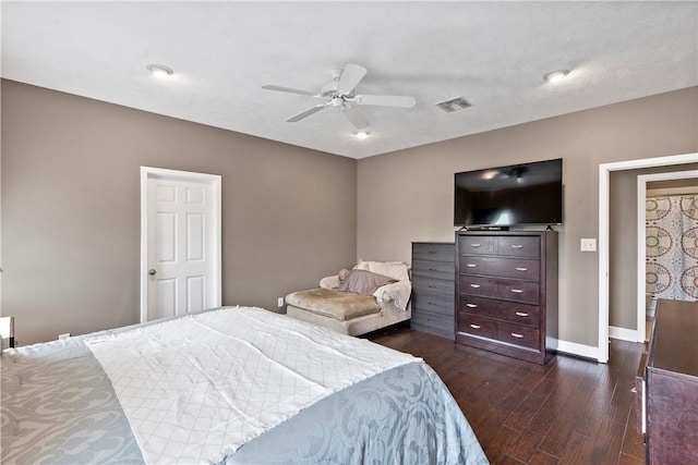 bedroom with baseboards, dark wood finished floors, visible vents, and a ceiling fan