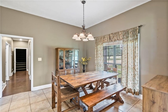 dining room with baseboards, a notable chandelier, and light tile patterned flooring