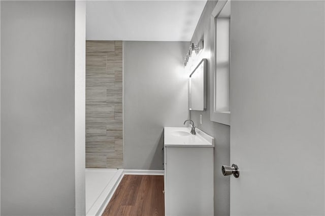 bathroom with a shower, hardwood / wood-style floors, and vanity