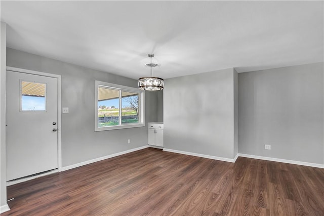 foyer featuring dark wood-type flooring and an inviting chandelier