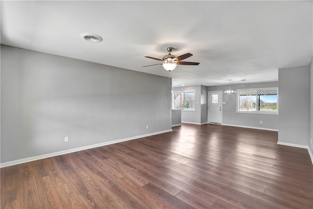 interior space featuring dark hardwood / wood-style floors and ceiling fan with notable chandelier