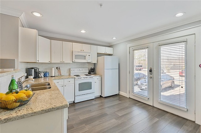 kitchen with french doors, decorative backsplash, ornamental molding, a sink, and white appliances