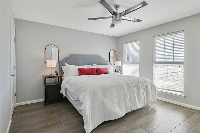 bedroom with a ceiling fan, dark wood-style flooring, and baseboards