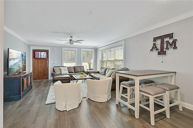 living room with baseboards, ceiling fan, ornamental molding, and wood finished floors