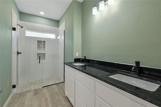 bathroom featuring tiled shower and vanity