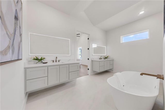 bathroom with a washtub and vanity