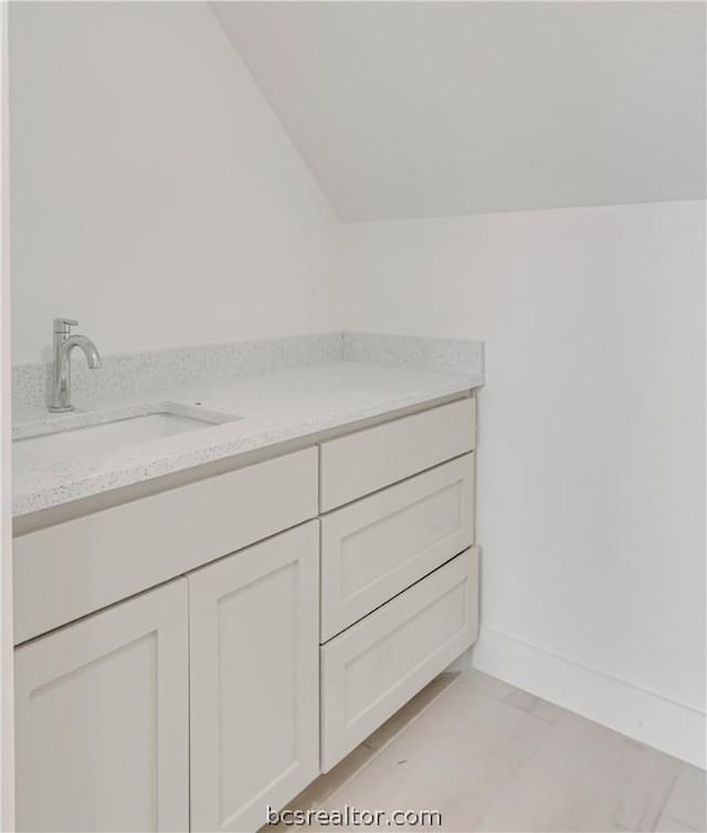 bathroom with vanity and lofted ceiling