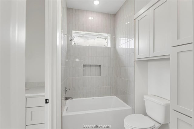 bathroom with tiled shower / bath combo and toilet