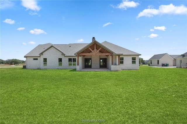 rear view of property with a yard
