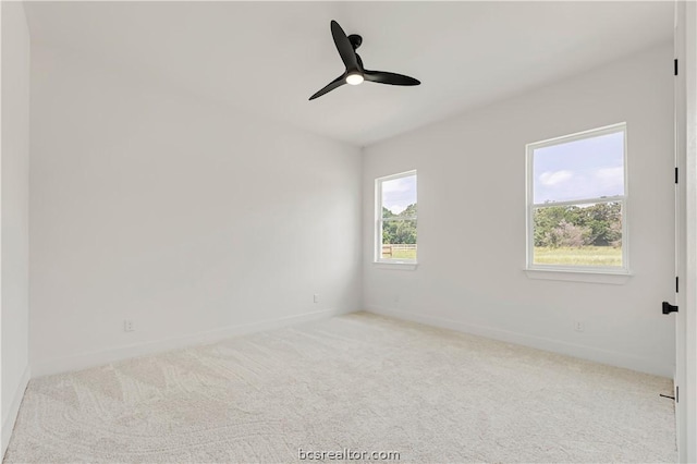 spare room with light colored carpet and ceiling fan