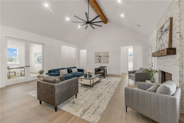 living room with ceiling fan, light hardwood / wood-style flooring, beamed ceiling, and high vaulted ceiling