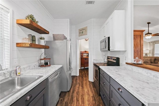 6866 Wooded Dr, College Station, TX 77845 - kitchen with stainless steel appliances, dark wood-style flooring, open shelves, crown molding, and gray cabinetry