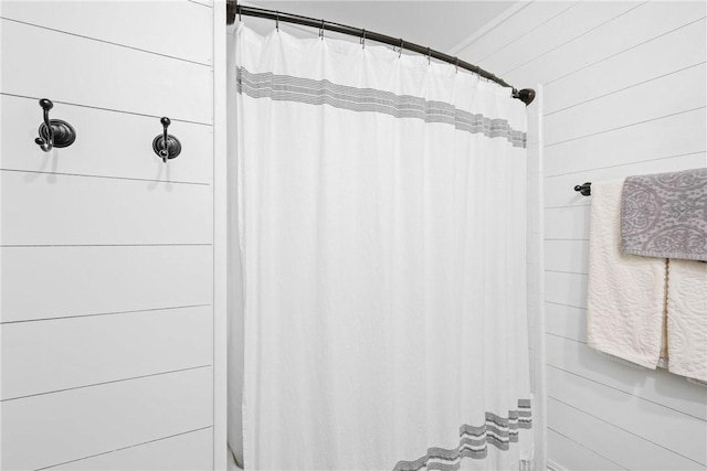 6866 Wooded Dr, College Station, TX 77845 - bathroom with a shower with curtain and wooden walls