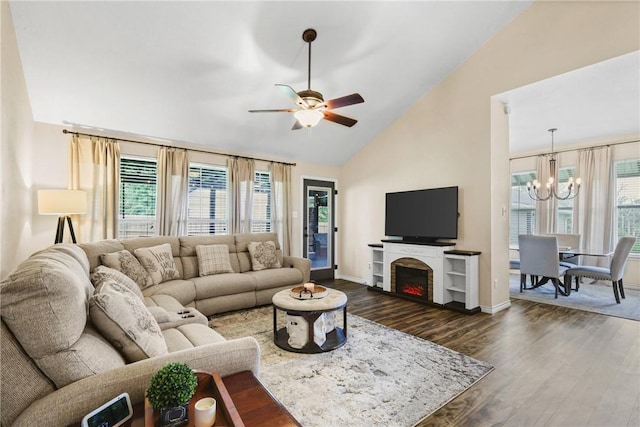 6866 Wooded Dr, College Station, TX 77845 - living room with a chandelier, a ceiling fan, dark wood finished floors, a lit fireplace, and high vaulted ceiling