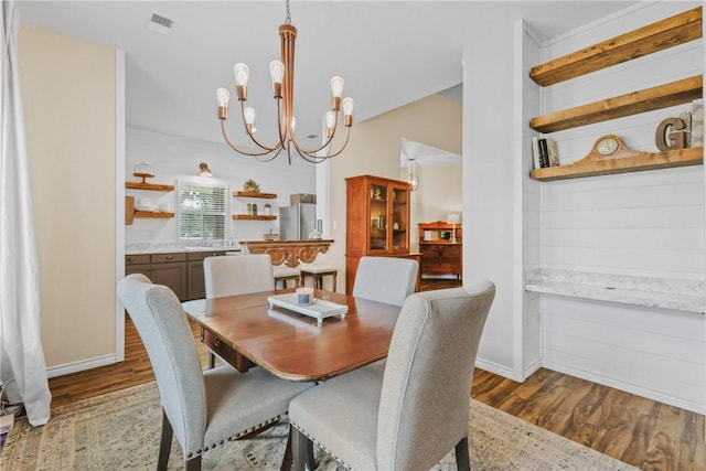 6866 Wooded Dr, College Station, TX 77845 - dining room featuring wood finished floors and a chandelier