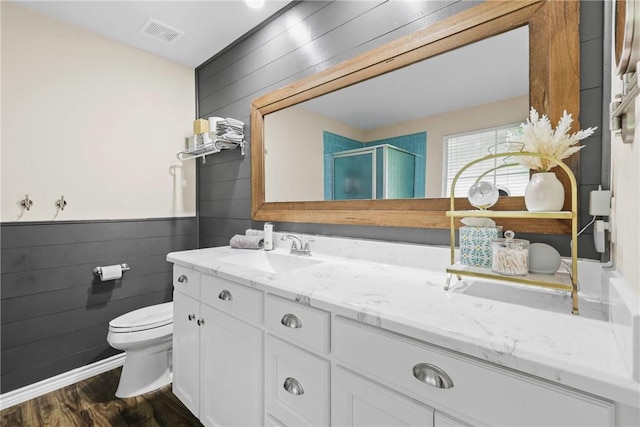 6866 Wooded Dr, College Station, TX 77845 - full bath featuring vanity, a shower stall, wood walls, wood finished floors, and a wainscoted wall