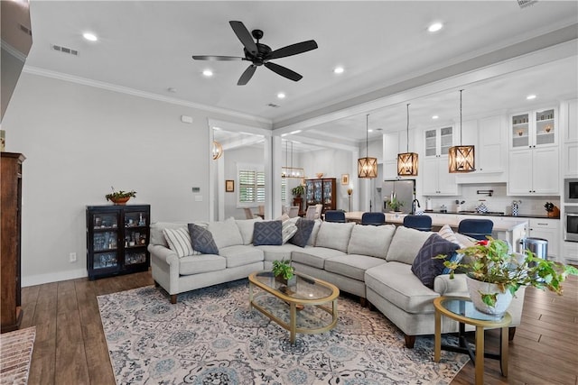 1909 Bareboot Trl, College Station, TX 77845 - living area with dark wood-style flooring, a ceiling fan, recessed lighting, ornamental molding, and a chandelier