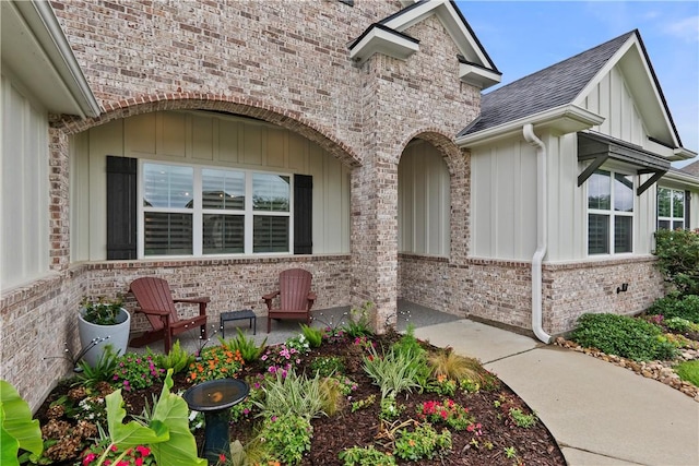 1909 Bareboot Trl, College Station, TX 77845 - view of side of home with brick siding, a shingled roof, board and batten siding, and a patio area