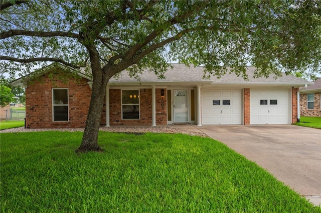 1003 Guadalupe Dr, College Station, TX 77840 - ranch-style home featuring concrete driveway, a front lawn, brick siding, and an attached garage