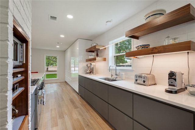 1003 Guadalupe Dr, College Station, TX 77840 - kitchen with open shelves, gray cabinets, light wood finished floors, appliances with stainless steel finishes, and backsplash