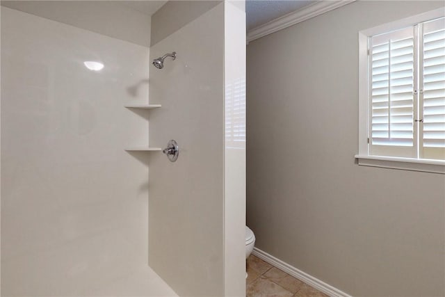 bathroom with baseboards, toilet, ornamental molding, tile patterned flooring, and walk in shower