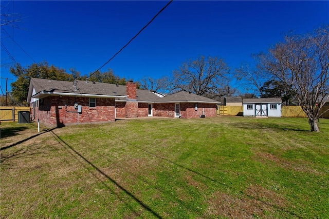 view of yard featuring an outbuilding, a fenced backyard, and a shed