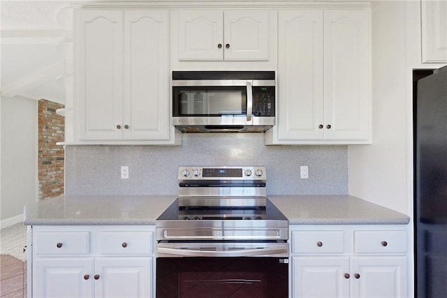 kitchen with stainless steel appliances, tasteful backsplash, and white cabinets