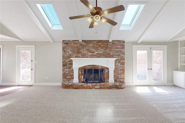 unfurnished living room featuring vaulted ceiling with beams, a brick fireplace, and carpet flooring