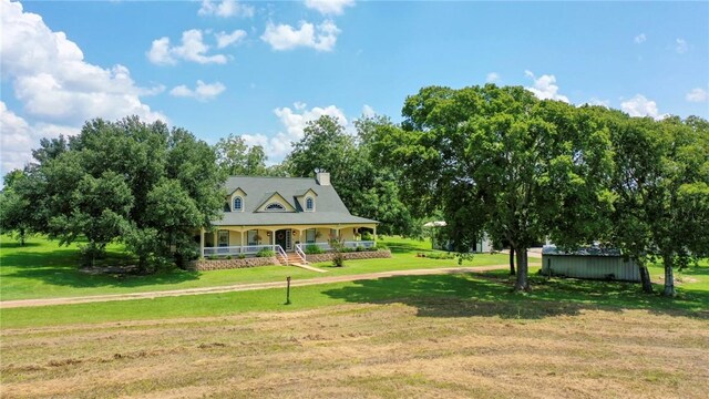 view of front of property featuring a front yard, a porch, and a shed