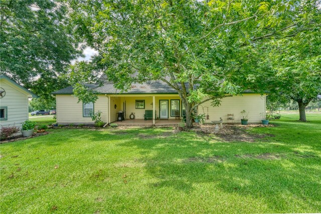 back of house featuring a patio area and a yard