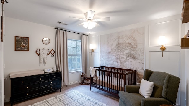 bedroom featuring visible vents, ceiling fan, baseboards, light carpet, and a nursery area