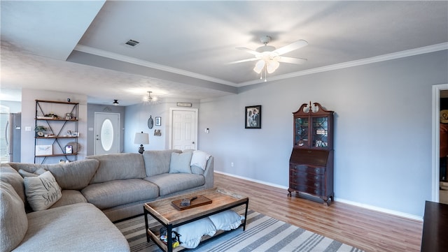 living room with visible vents, crown molding, baseboards, and wood finished floors