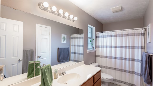 bathroom with vanity, a shower with shower curtain, and toilet