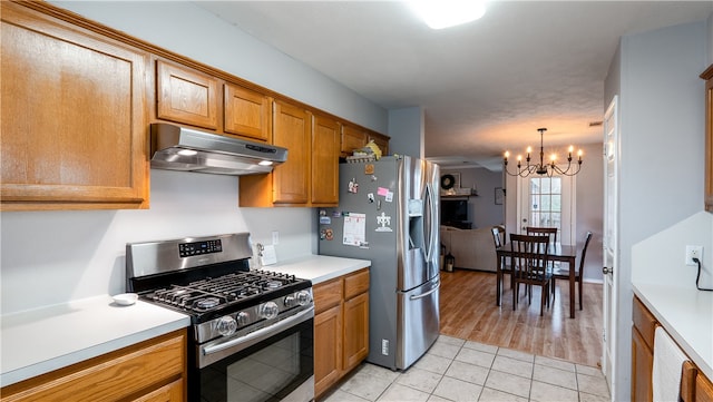 kitchen featuring under cabinet range hood, appliances with stainless steel finishes, light countertops, and brown cabinetry