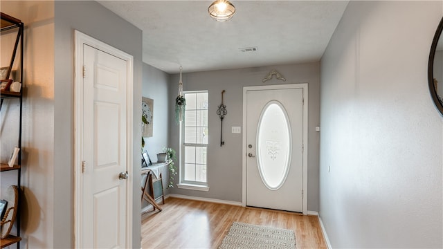 entrance foyer with visible vents, light wood-style flooring, and baseboards