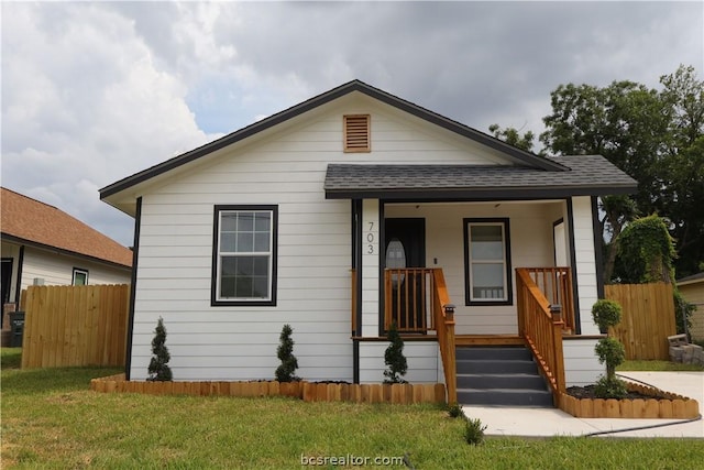 bungalow with covered porch and a front yard