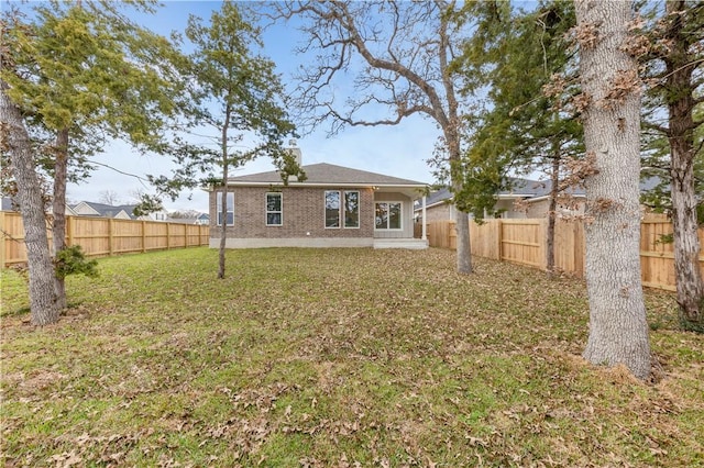 rear view of property featuring a lawn