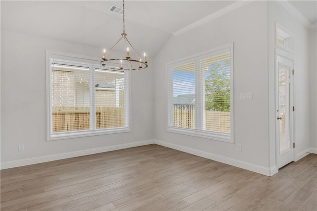 unfurnished dining area featuring crown molding, light wood-type flooring, vaulted ceiling, and a notable chandelier