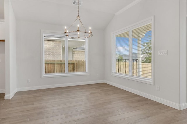 unfurnished dining area with light wood-type flooring, crown molding, and an inviting chandelier