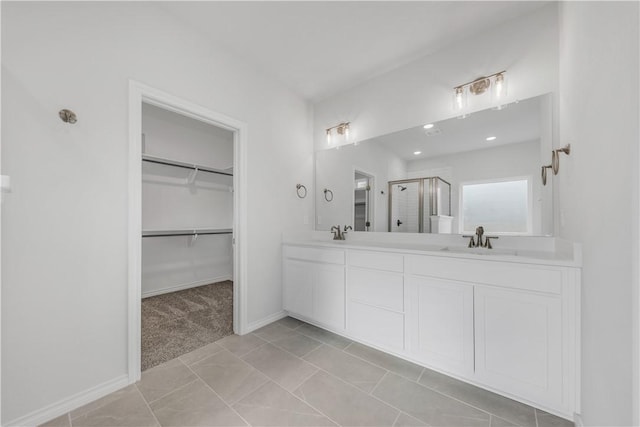 bathroom featuring tile patterned flooring, vanity, and a shower with shower door