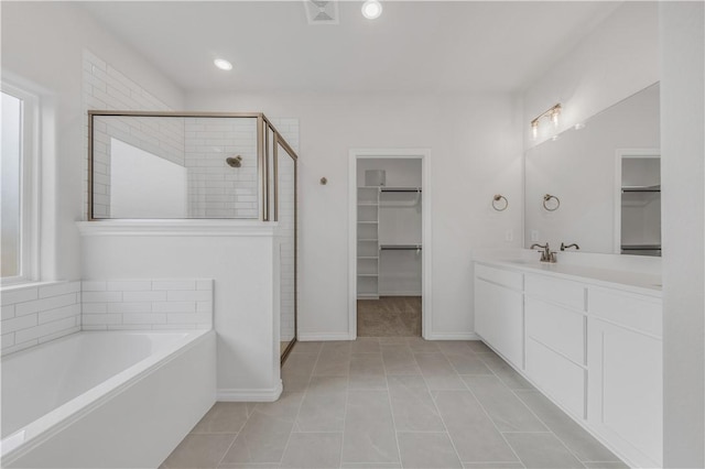 bathroom with tile patterned floors, vanity, and plus walk in shower