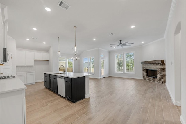 kitchen featuring white cabinetry, sink, a kitchen island with sink, ceiling fan with notable chandelier, and appliances with stainless steel finishes