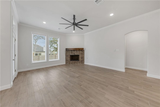 unfurnished living room with ceiling fan, crown molding, a fireplace, and light hardwood / wood-style flooring