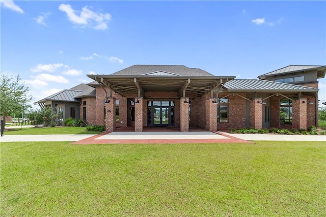 4209 Harding Ct, Bryan, TX 77802 - back of house with a yard, a standing seam roof, and brick siding