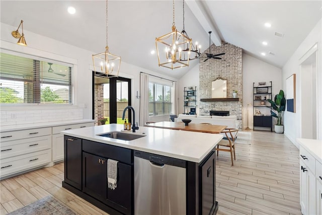 4209 Harding Ct, Bryan, TX 77802 - kitchen with a sink, dishwasher, a chandelier, a fireplace, and light countertops