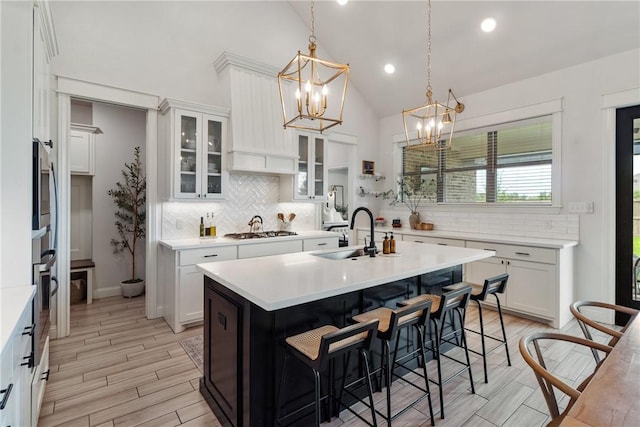 4209 Harding Ct, Bryan, TX 77802 - kitchen featuring a sink, stainless steel gas cooktop, a chandelier, backsplash, and an island with sink